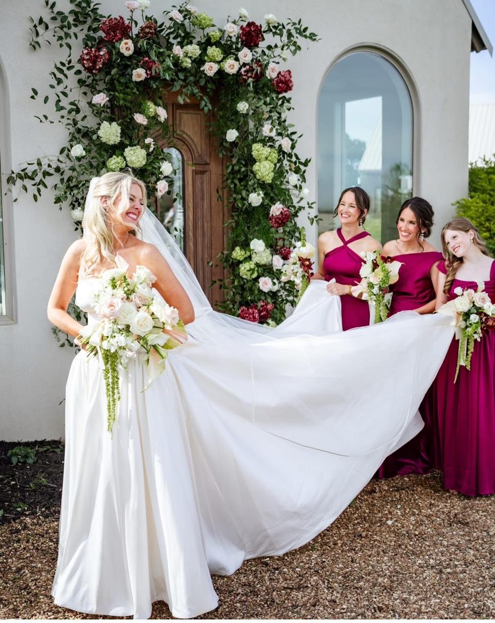 Bride with bridesmaids and floral arch