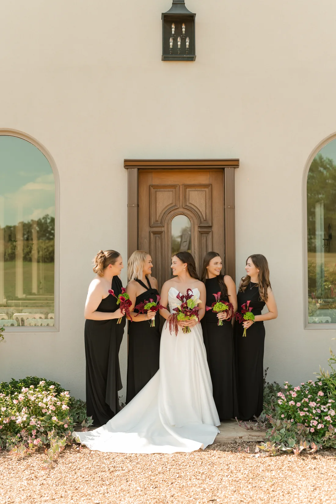 Madisyn and her bridesmaids in black with jewel-tone bouquets at the chapel at Gateley Hill Gardens