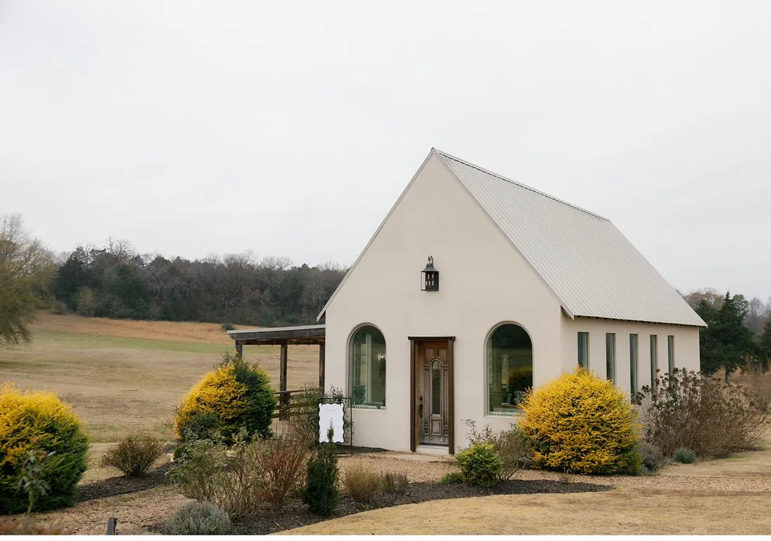 White stucco chapel with winter landscaping and bare trees at Gateley Hill Gardens