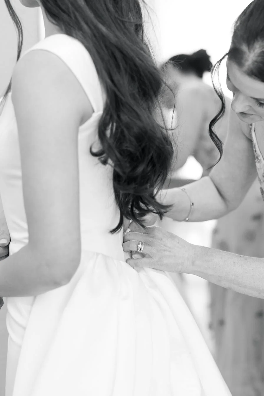 Mother of the bride buttoning the dress